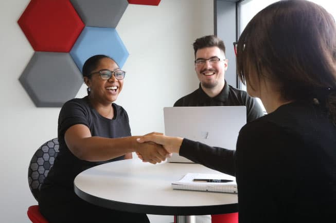 Don’t be a target. Be secure with Target Defense. Employee shaking hands with happy client